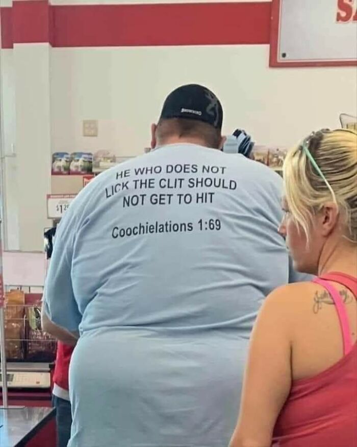 Man wearing a humorous shirt with a bold message standing in line, example of wild People of Walmart style fashion.