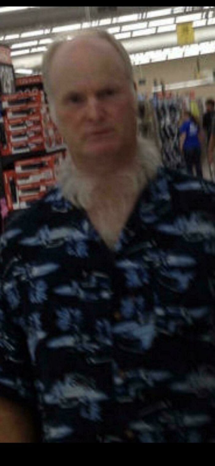 Middle-aged man with unusual neck hair wearing a patterned shirt inside a Walmart store, part of wild People of Walmart pics.