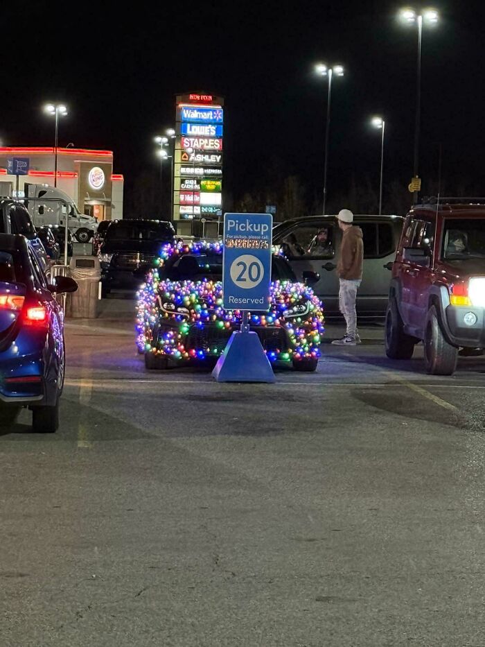 Car covered in colorful lights parked in a Walmart pickup zone at night showcasing wild People of Walmart style.