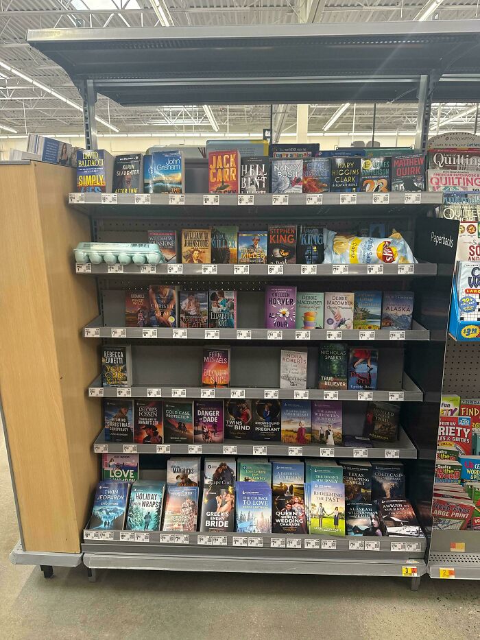 Bookshelf in a Walmart store filled with various novels showcasing a typical People of Walmart retail display.