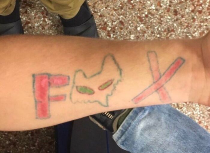 Arm tattoo fail showing poorly drawn letters and shapes with uneven coloring, highlighting common tattoo fail mistakes.