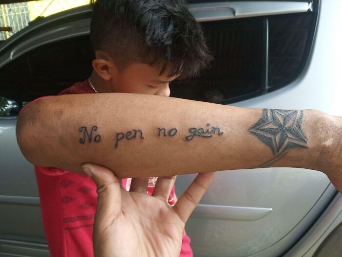 Tattoo fail showing a misspelled quote no pen no gain on forearm next to a star design on a person's arm.