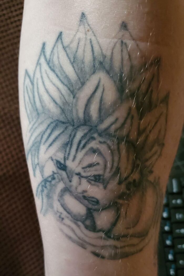 Tattoo fail of a poorly drawn anime character with blurry lines and shading on a person's arm, an epic tattoo fail example.