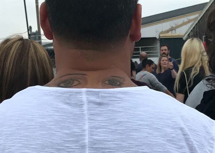 Tattoo fail showing large eyes tattooed on the back of a man’s neck, creating an unusual and epic visual effect.