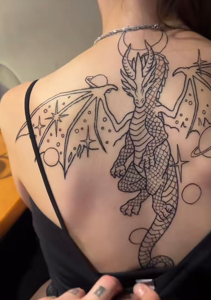 Dragon tattoo fail on a woman’s back with sparse line work and uneven detail, highlighting epic tattoo fails shared online.