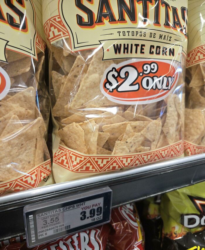 Bags of Santitas white corn chips with in-store price labels showing higher prices, illustrating sneakflation examples.