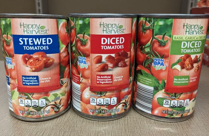 Three cans of Happy Harvest tomatoes with different labels and sizes, illustrating examples of sneakflation in grocery products.