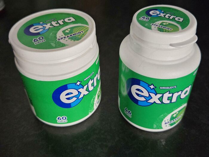 Two containers of Wrigley's Extra spearmint gum on a dark surface illustrating examples of sneakflation in product packaging.
