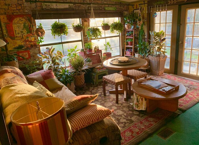 Cozy living room filled with lush plants and vintage furniture showcasing a charming cottage core aesthetic.