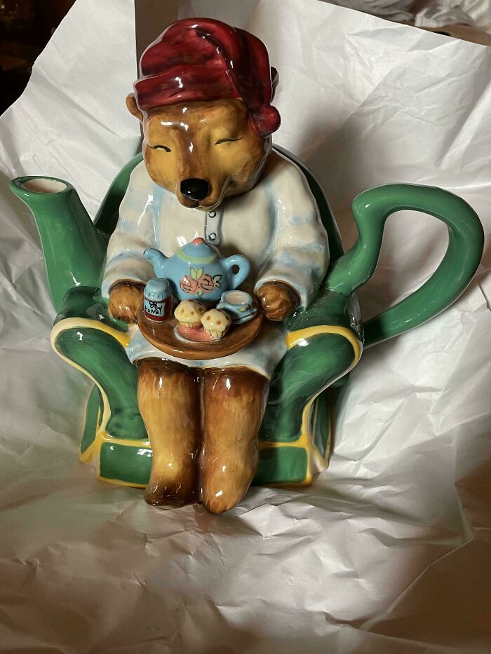 Ceramic teapot shaped like a bear in pajamas holding a tray of tea and cookies, cottage core aesthetics decor.