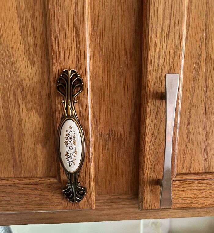 Ornate vintage and modern cabinet handles on wooden doors showcasing cottage core aesthetics in a whimsical kitchen setting.