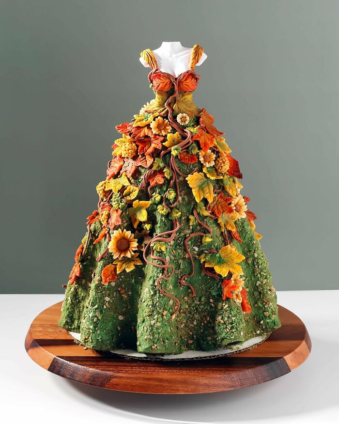 Dress-shaped cake decorated with autumn leaves and flowers, embodying cottage core aesthetics and natural beauty.