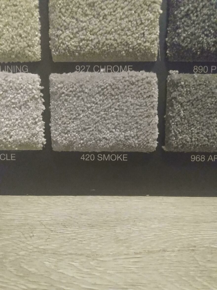 Carpet samples in neutral colors labeled with names and numbers, showcasing texture for flooring choices.
