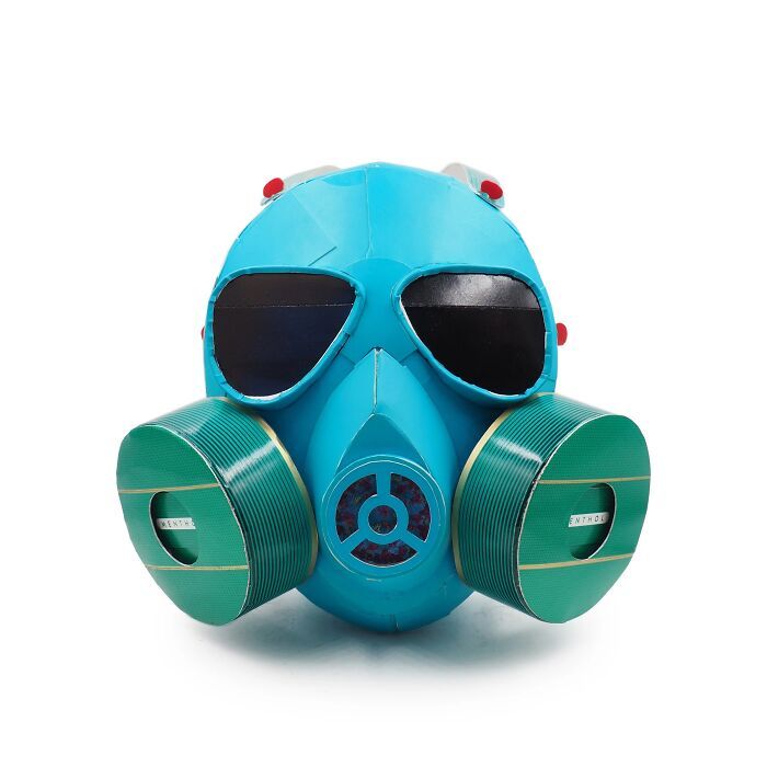 Sculpture of a gas mask made from waste materials, showcasing witty commentary on modern life through art.
