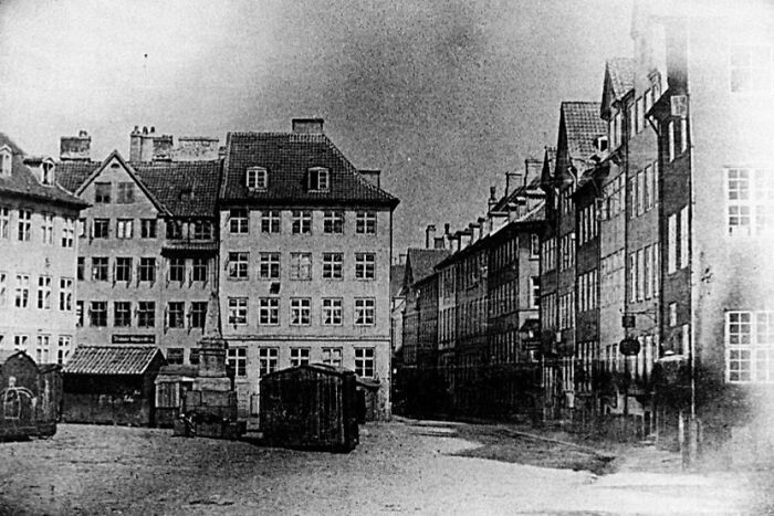 Black and white photo showing what a world capital looked like way before modern times with old buildings and empty streets.
