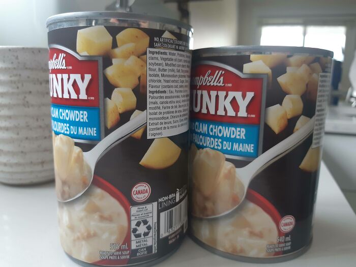 Two cans of Campbell’s Chunky clam chowder on a kitchen counter, illustrating examples of sneakflation in food products.
