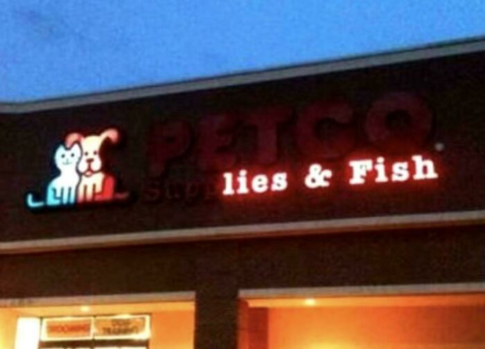 LED sign at pet store showing a humorous partially lit message with the words lies and fish at night