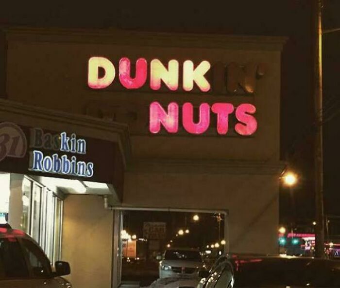LED sign with partially unlit letters creating a humorous effect on a Dunkin' Donuts storefront at night.