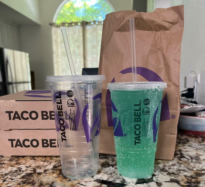 Two Taco Bell drinks and food containers on a kitchen counter illustrating examples of sneakflation in fast food pricing.