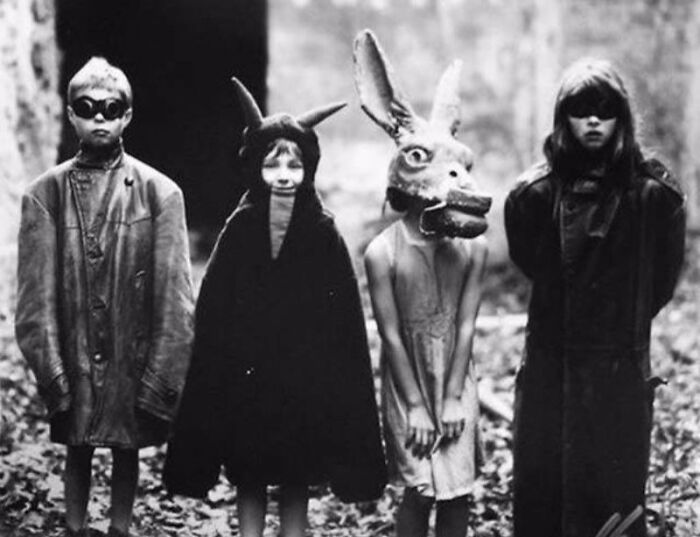 Four children wearing eerie Halloween costumes from the past, showcasing vintage Halloween costumes that are both terrifying and impressive.