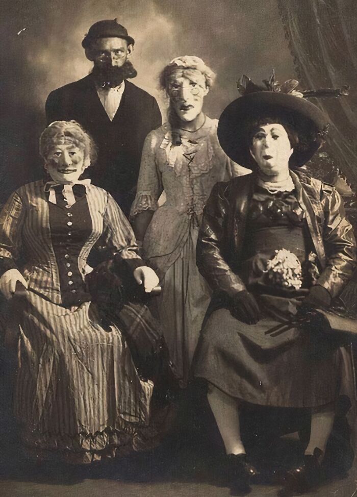 Vintage Halloween costumes from the past with terrifying and impressive masks and outfits in a black and white photo.
