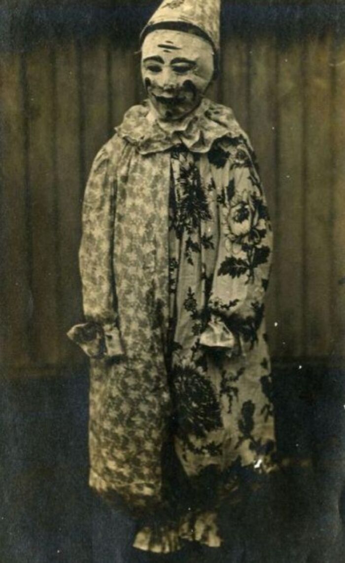 Vintage Halloween costume with eerie clown makeup and patterned outfit, a terrifying and impressive Halloween look from the past.