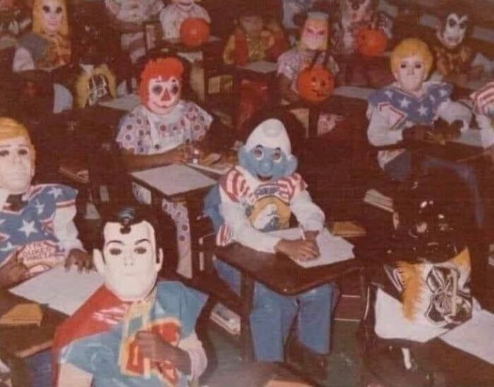 Children wearing vintage Halloween costumes and masks in a classroom, showcasing terrifying and impressive past Halloween costumes.
