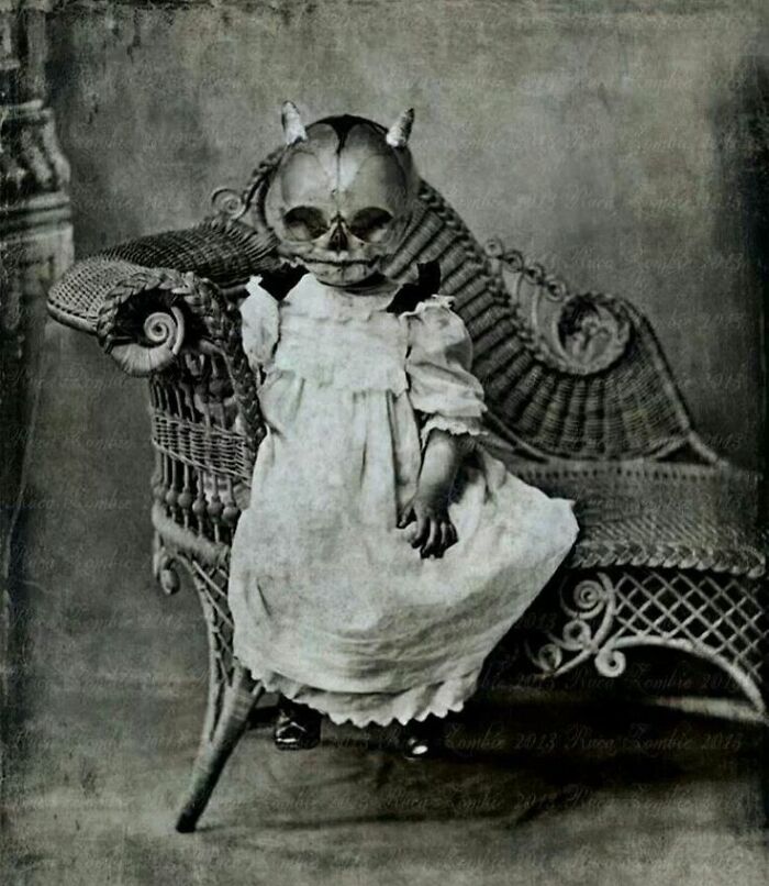 Vintage Halloween costume featuring a child in a creepy skull mask and old-fashioned dress sitting on a wicker chair.