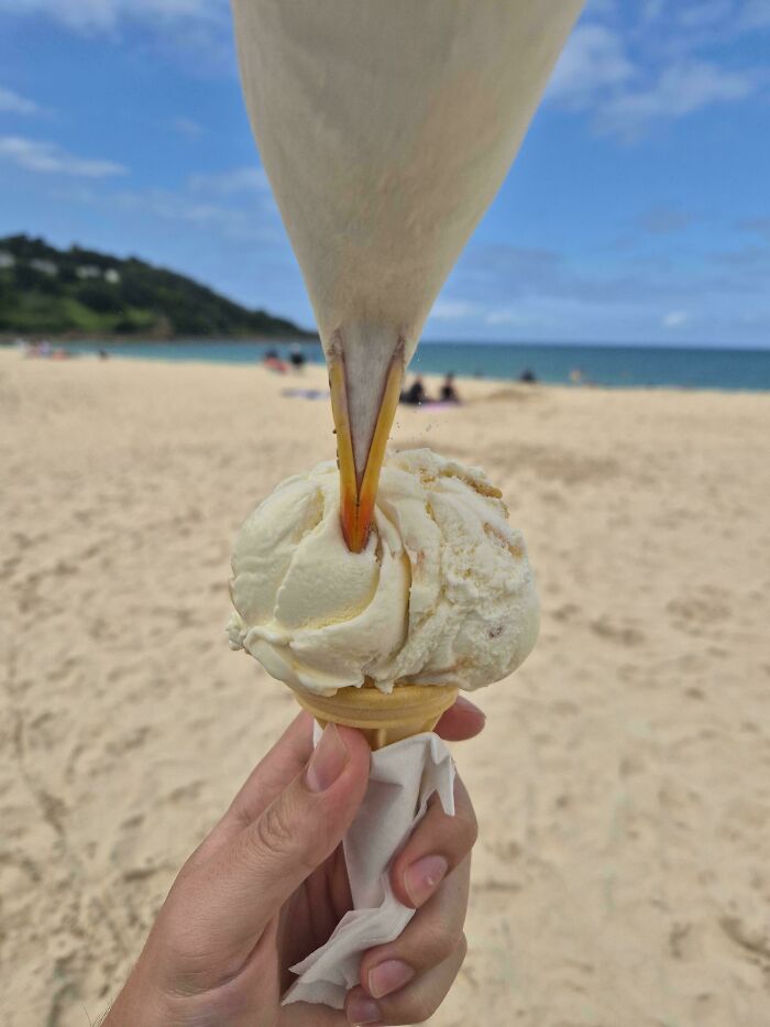 Seagull about to snatch ice cream cone from hand on a beach in a hilarious photo before disaster struck.