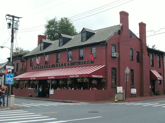 Historic brick tavern at a street corner, a popular spooky destination for visitors seeking haunted Halloween sites.