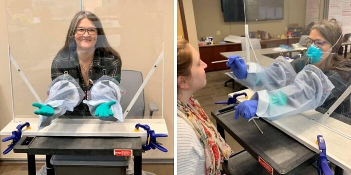 Healthcare worker in protective gear conducting a medical test through a clear barrier with built-in gloves.
