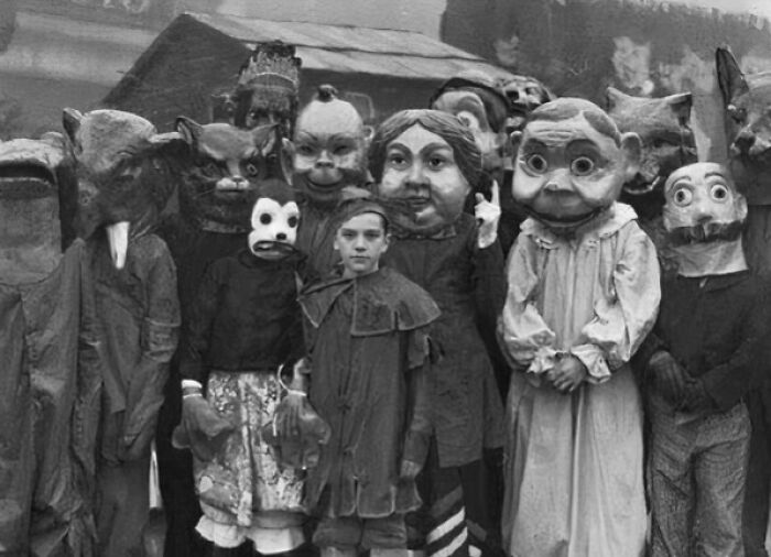 Group of children wearing vintage Halloween costumes with large, eerie masks, showcasing terrifying and impressive designs from the past.