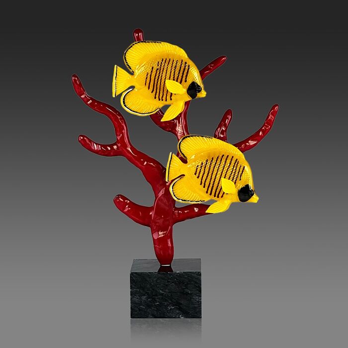Yellow glass fish sculpture mounted on red coral glass base, showcasing stunning ocean life glass art.