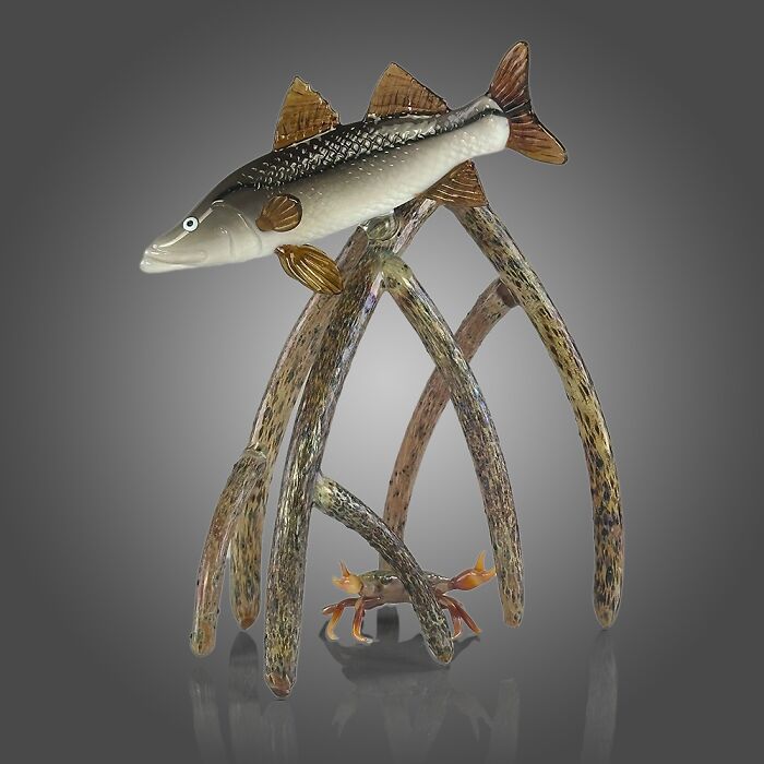 Glass sculpture of an ocean fish and crab among coral-like structures showcasing stunning ocean life artistry.