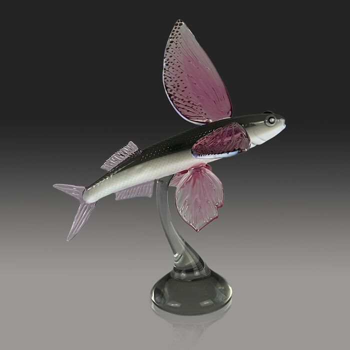 Glass sculpture of a flying fish with translucent pink fins showcased as a stunning ocean life glass artwork.