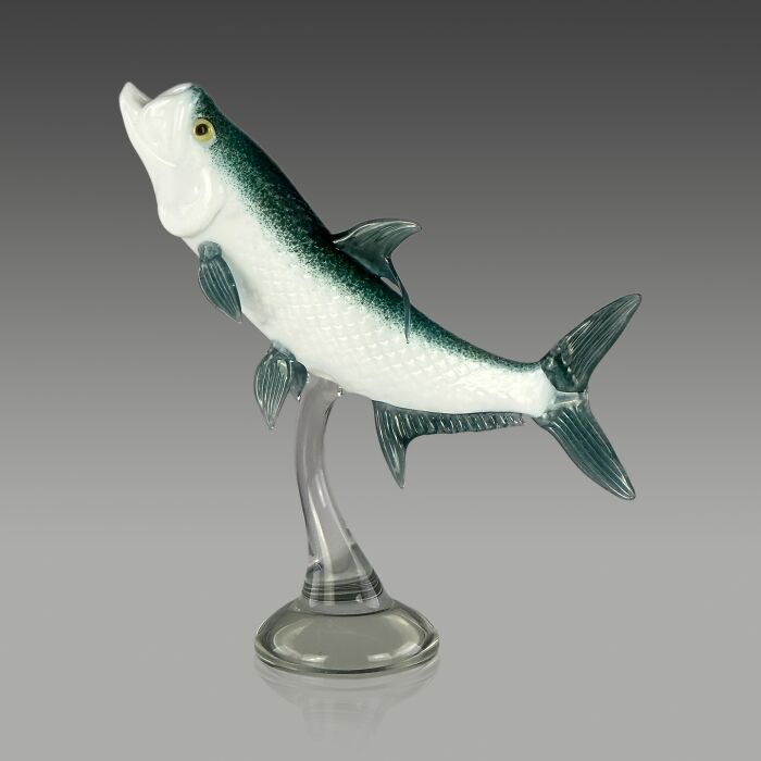 Glass sculpture of a detailed fish with green and white colors, showcasing ocean life in a dynamic swimming pose.