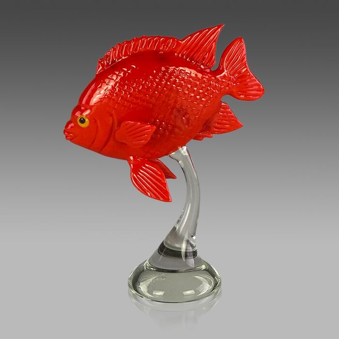 Red glass fish sculpture mounted on a clear glass stand showcasing stunning ocean life glass art.