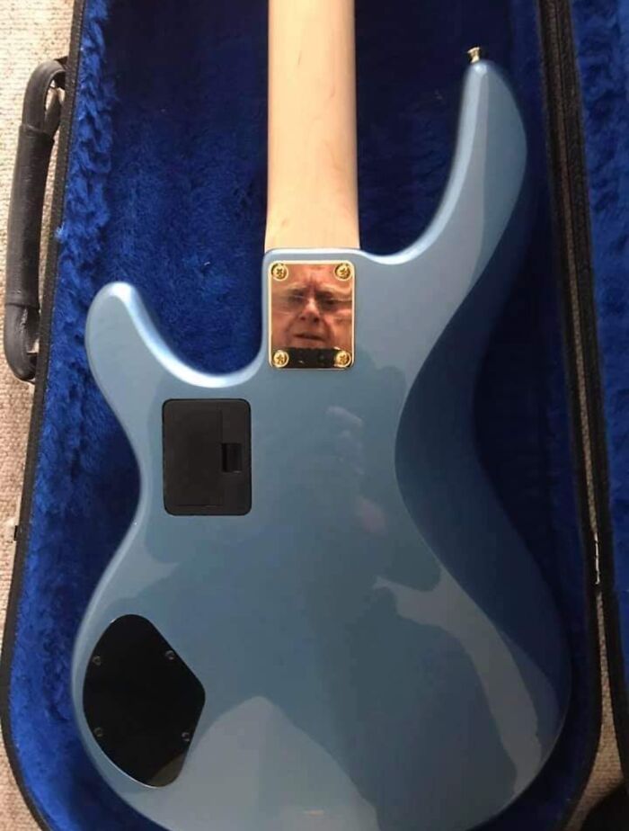 Blue electric guitar with a mirror plate reflecting a man's face, showcasing a funny mirror reflection selling moment.