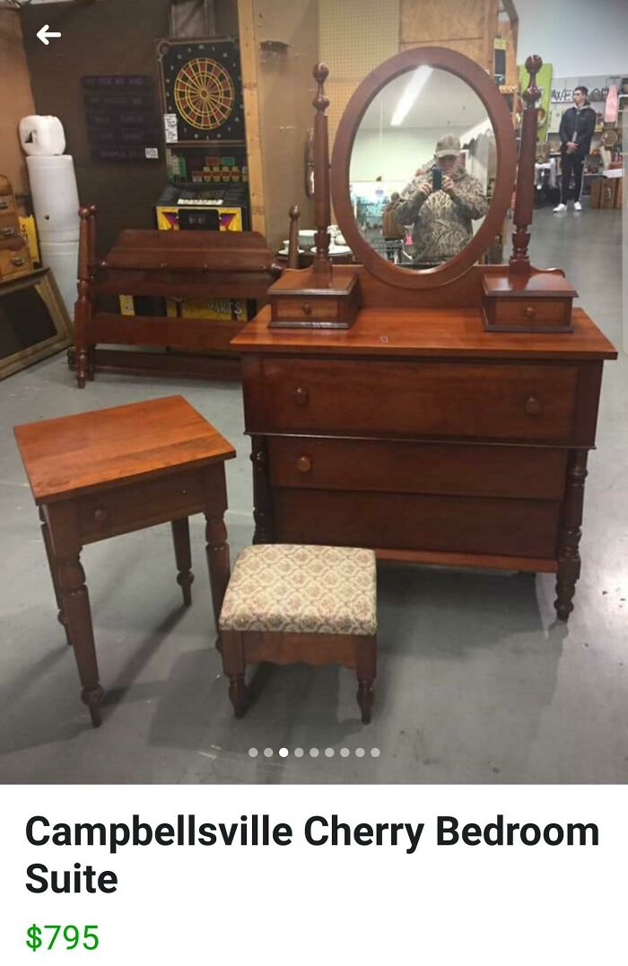 Vintage cherry bedroom suite with mirror reflecting person taking a photo, highlighting hilarious times people sold a mirror.