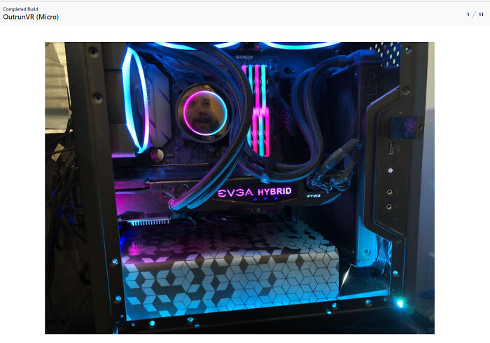 Reflection of a man's face visible in a colorful RGB-lit computer setup, showcasing the mirror effect selling the item.