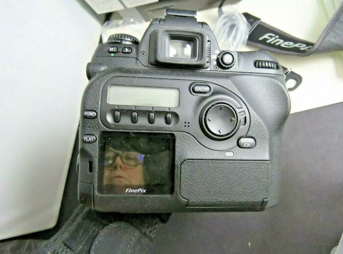 Close-up of a digital camera showing a reflection of a person on its screen, highlighting mirror reflection selling humor.