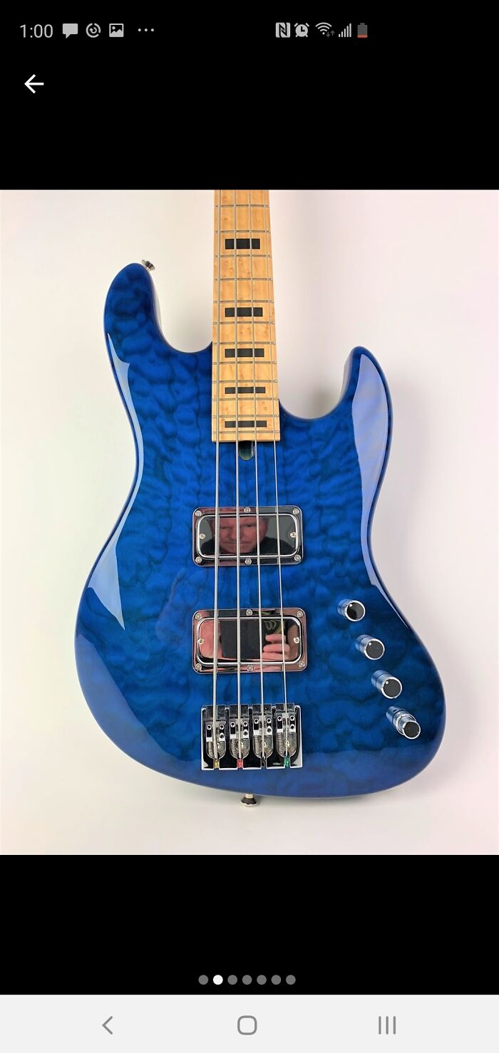 Blue electric guitar with a glossy reflection showing a person taking a photo, highlighting the reflection sold it concept.