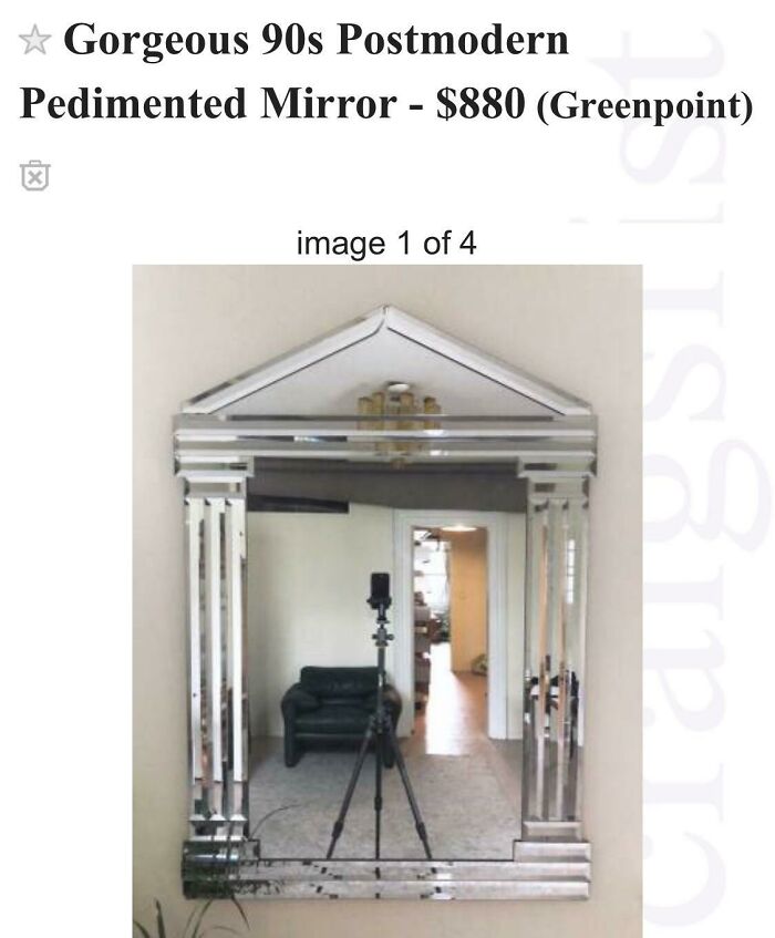 Postmodern pedimented mirror reflecting a cozy living room and tripod camera, highlighting mirror reflection selling appeal.
