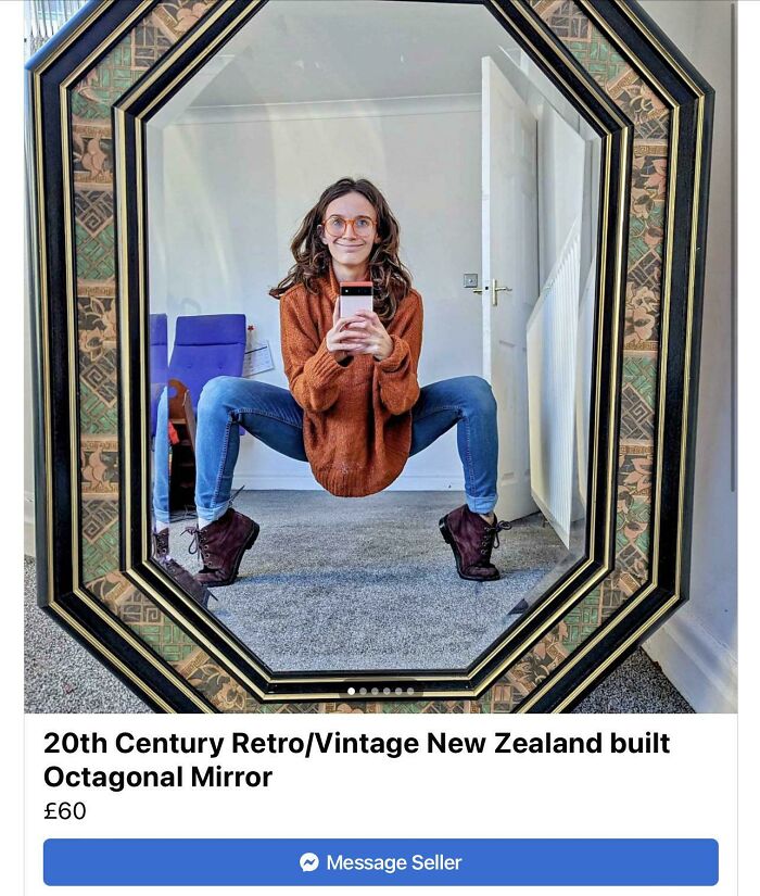 Person reflected in a vintage octagonal mirror wearing glasses and an orange sweater, creatively showing the mirror's appeal.