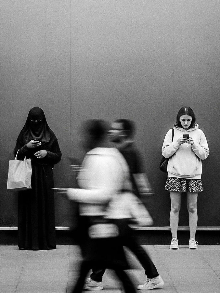 Black and white street photograph capturing the beauty of everyday life in India with diverse individuals on their phones.
