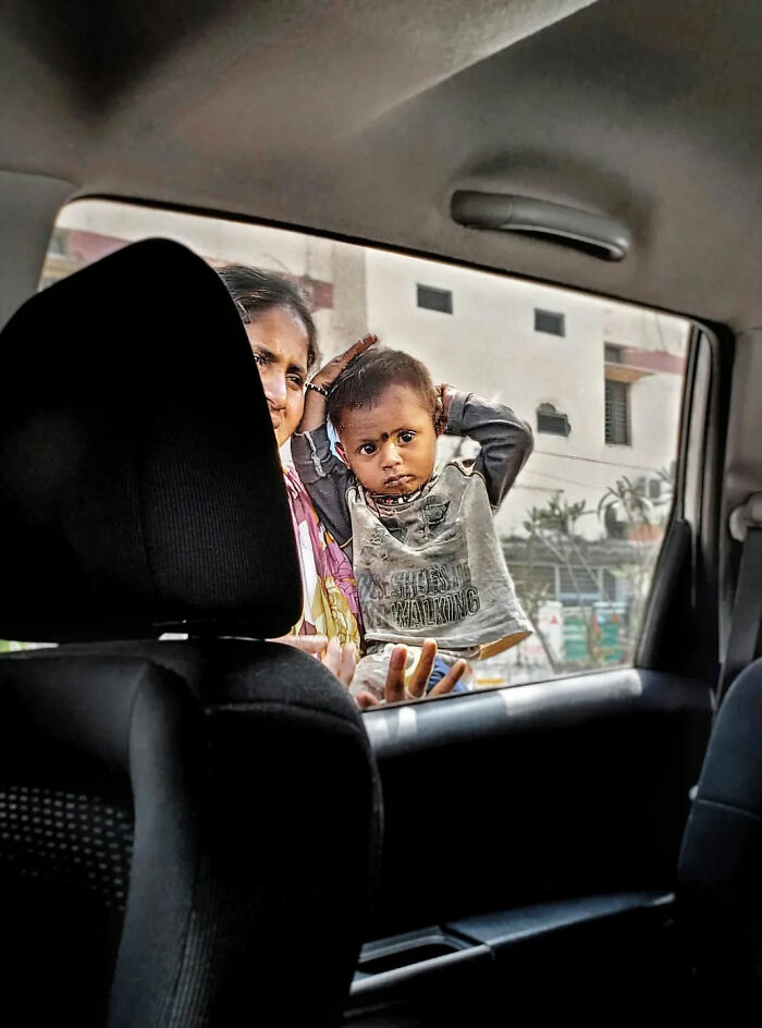 Child and woman outside a car window, capturing the beauty of everyday life in India by a street photographer.