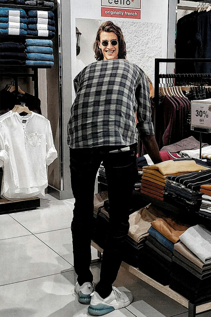 Man wearing sunglasses and a plaid shirt shopping in a store, capturing the beauty of everyday life in India.