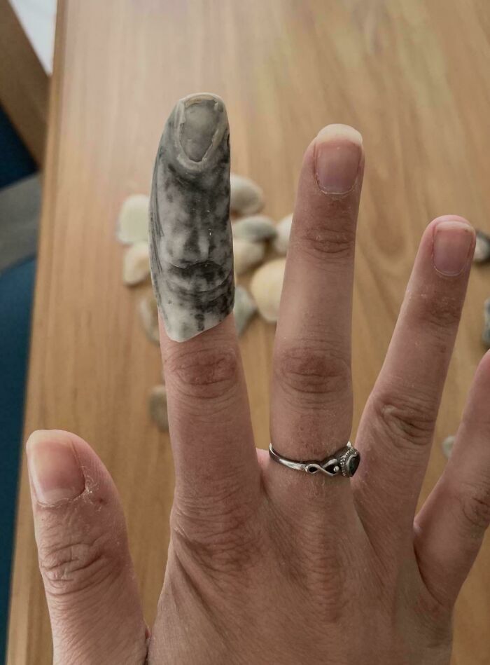 A hand with a natural stone shaped like a finger, highlighting unexplained phenomena from an interesting group.