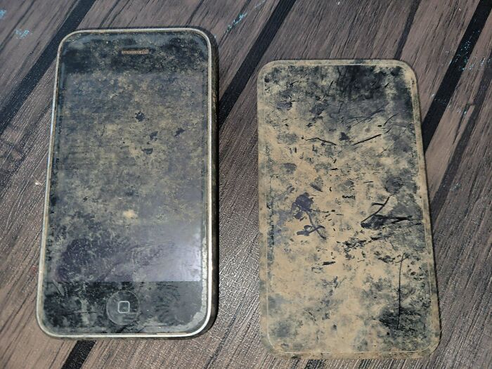 Two old smartphones covered in dirt and grime, showcasing interesting items that cannot be explained clearly.