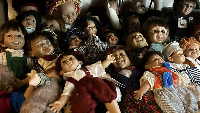 A collection of vintage dolls with eerie expressions, showcasing some things that cannot be explained in this interesting group.